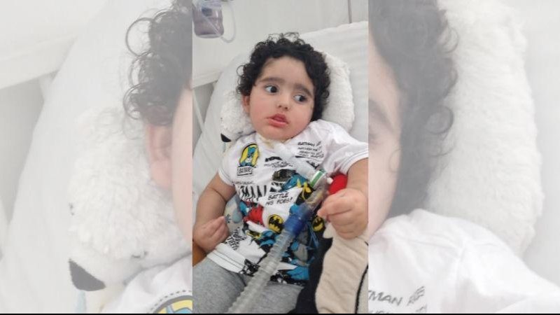 Pequeno guerreiro sofreu diversos danos neurológicos após afogamento Rhavi luta pela vida há mais de um ano; família pede ajuda para continuar os tratamentos Foto da criança deitada em uma maca recebendo cuidados médicos - Cristina Barros