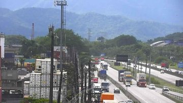 Chegada a Santos pela via Anchieta também tem lentidão, do km 64 ao km 65 Anchieta e Imigrantes têm grande fluxo de veículos e lentidão nesta manhã Caminhões e veículos de passeio transitando pela via Anchieta, na entrada de Santos, com montanhas ao fundo - Ecovias