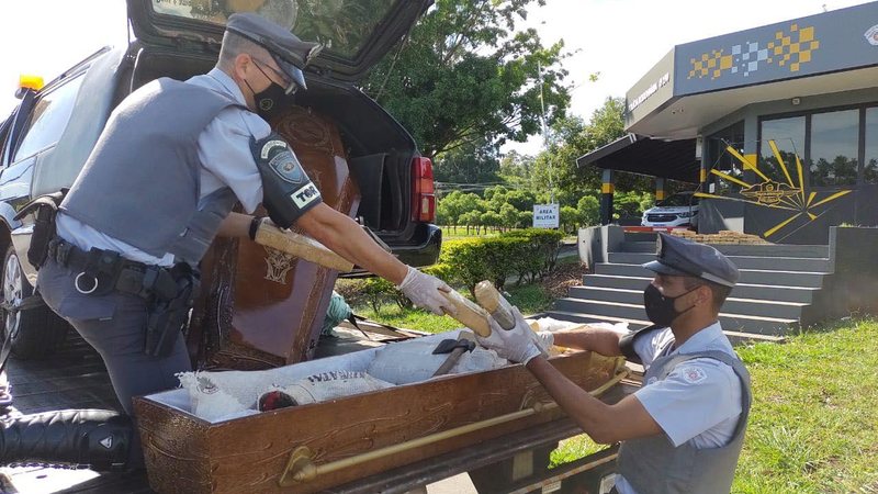 Policiais militares localizam droga dentro de urna funerária que seria levada para Limeira (SP) Maconha escondida dentro de caixão é apreendida no interior de São Paulo Dois policiais rodoviários contam os tijolos de maconha que estavam dentro de um caixão - Divulgação/Polícia Rodoviária