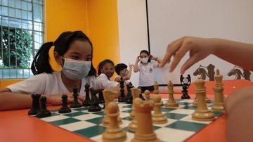 Com visível talento, jovem de apenas 8 anos é considerada uma promessa na modalidade Conheça Elisa Feng, a jovem santista que dá show no xadrez por todo Brasil Elisa Feng jogando xadrez durante atividade escolar - Divulgação/PMS