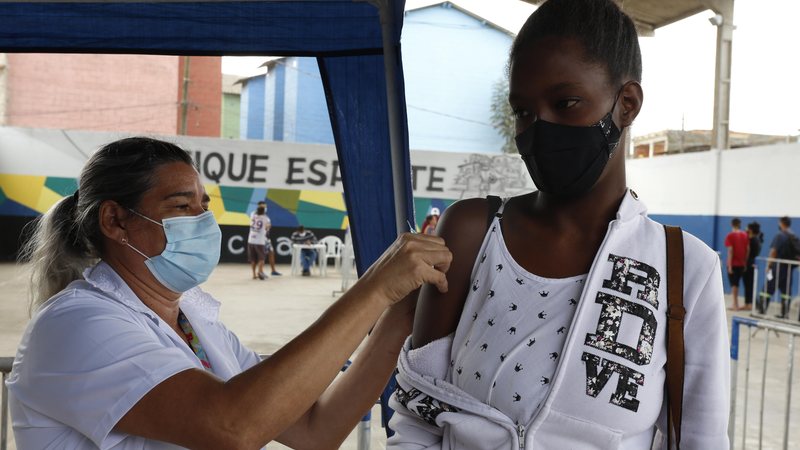 Ação da prefeitura será das 9 às 15 horas Mutirão de Vacinação acontece na comunidade da Pedreira, nesta quarta (17) Jovem tomando vacina em Guarujá - Divulgação/Diego Marchi