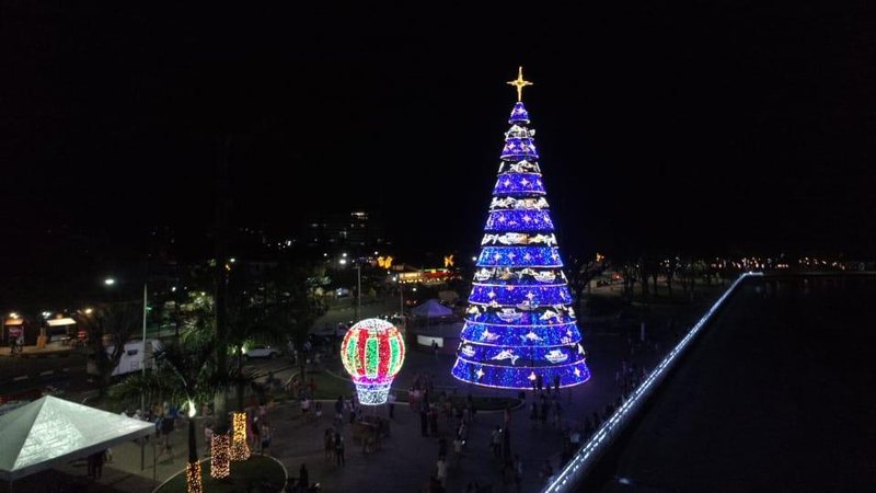 Decoração natalina foi acesa na sexta-feira (26) em Bertioga Magia do Natal chega à Bertioga e inspira moradores Canal de Bertioga visto de cima com árvore de Natal gigante iluminada e balão menor iluminado - Renato Inácio