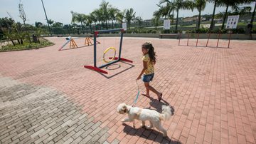 No Dog Park há brinquedos e uma grande área cercada para os pets se divertirem Parque da Cidade em Praia Grande é opção de lazer para moradores e turistas Criança brinca com cachorro no Dog Park de Praia Grande - Site Turismo Praia Grande