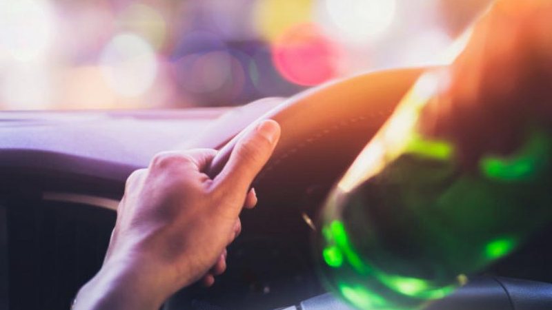Passageiro do veículo estava com sinais de embriaguez e não pode dirigir; carro foi encaminhado ao Pátio Municipal Mulher dirige bêbada, derruba poste e perde CNH Imagem ilustrativa de um motorista bebendo - Imagem ilustrativa