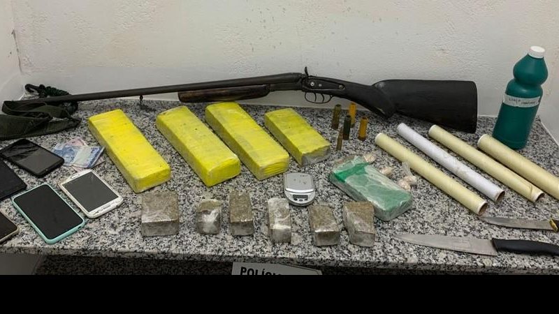 Homem é preso com espingarda e drogas após ameaçar moradores em Caraguatatuba  espingarda e drogas sobre a mesa - Foto: Divulgação/ Polícia Militar