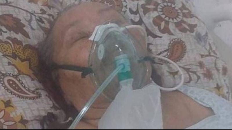 Senhora internada há cerca de 25 dias aguarda transferência de hospital Filho desabafa: "hospital do município não tem UTI e o suporte necessário para atender minha mãe" Mulher acamada com aparelhos no rosto - Reprodução Facebook
