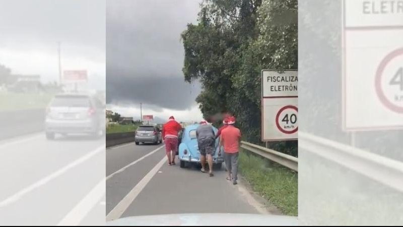 Flagrante aconteceu na rodovia Rio-Santos, em Bertioga, na altura do bairro Vista Linda Flagrante: Fusca do Papai Noel enguiça em Bertioga | VÍDEO Homens com gorros de Papai Noel empurram Fusca azul na rodovia Rio-Santos - Instagram Aconteceu em Bertioga