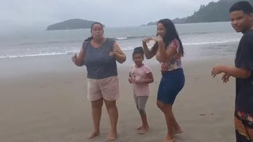 Família de Ubatuba apelou para a dança da chuva ao contrário para ver se o sol aparece Moradores de Ubatuba cansam da chuva e apelam para "ritual" Mãe e filhos dançando na praia - Reprodução Facebook