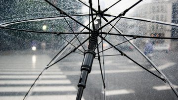 A previsão indica que deve chover durante toda a sexta-feira (7) e o sábado (8) Previsão do tempo: Litoral de São Paulo deve continuar molhado nesta sexta-feira (7) Guarda-chuva transparente aberto respingado de chuva com avenida ao fundo. - Pixabay