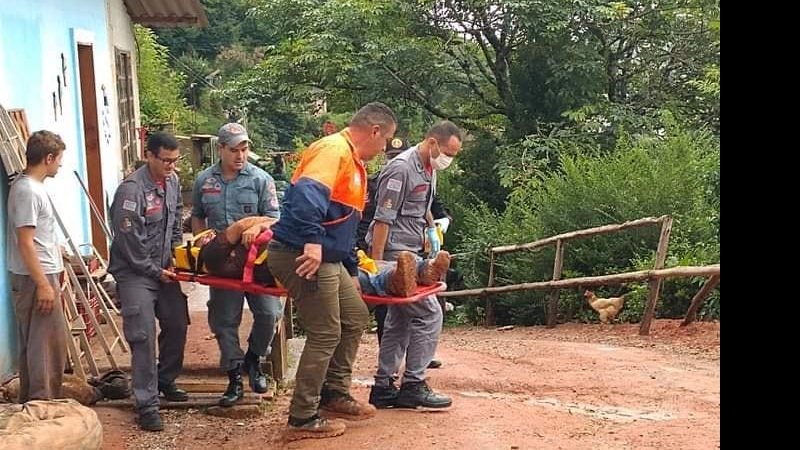 Força tarefa resgata vítima com vida Homem foi soterrado por deslizamento de terra; equipes o resgatam com vida Homem sendo carregado em maca pelas equipes do resgate - Reprodução Facebook