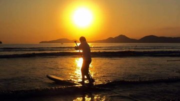 As regras são para atividades esportivas na areia e no mar Santos publica normas para praticar esporte na praia e gera polêmica entre a população Pessoa praticando stand up paddle - Reprodução Facebook