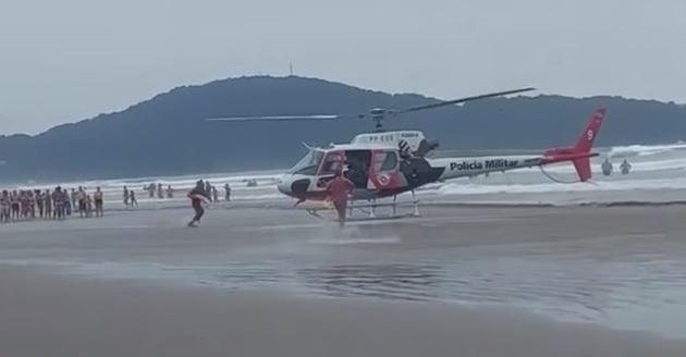 Operação conjunta entre o helicóptero Águia da Polícia Militar e salva-vidas foi realizada para resgate das vítimas de afogamento Tarde de domingo foi marcada por afogamentos em Praia Grande | VÍDEO Helicóptero Águia da Polícia Militar pousa na praia do ba - Reprodução/Praia Grande Mil Grau