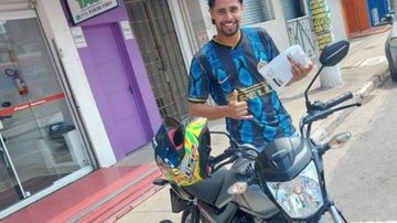 Henrique tirou uma foto todo feliz em frente à concessionária quando foi buscar a moto nova Internautas choram tragédia e morte em tentativa de assalto Jovem fazendo pose ao lado da moto e em frente a loja - Reprodução Facebook