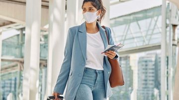 Passará a ser obrigatório apresentar comprovante de vacina e tete negativo para Covid-19 Governo federal torna obrigatório passaporte da vacina para entrar no Brasil Mulher chegando no aeroporto com uma mala na mão e documento na outra - Divulgação/Freepik