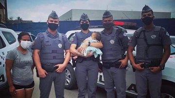 Imediatamente os agentes de segurança iniciaram uma manobra  para desobstruir as vias aéreas do nenê Bebê desacordado é salvo por policiais militares em Cubatão Policiais  que realizaram o salvamento com o bebê no colo - Reprodução Facebook