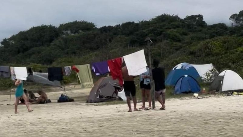 População afirma que os acampantes eram indígenas e concordam com a atitude deles Suposto acampamento é montado em praia e gera polêmica na internet Foto das barracas e do varal cheio de roupas instalados na areia da praia - Reprodução Facebook