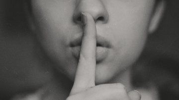 Polícia Militar e Guarda Civil Municipal chegaram a ir ao local dos fatos três vezes no mesmo dia Briga de vizinhos motivada por culto religioso acaba na delegacia em PG Foto em preto e branco de mulher fazendo sinal de silêncio - Kristina Farinha / Unsplash