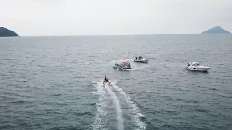 Capitania dos Portos investiga o caso e tenta encontrar o dono da embarcação Lancha pega fogo em praia de São Sebastião Imagem aérea do mar com a lancha e embarcações do grupamento de bombeiros marítimo - Reprodução Facebook