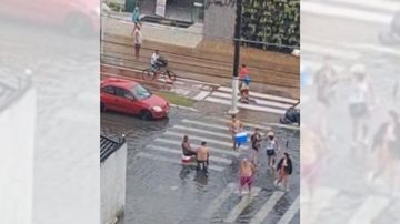 Nem as fortes pancadas de chuva que atingiram Praia Grande nos últimos dias foram suficientes para tirar o ânimo dos turistas Sem estresse: Alagamentos não abalam nem um pouco turistas de PG | VÍDEO Turistas sentam em meio a ponto de alagamento na avenida  - Reprodução/Instagram
