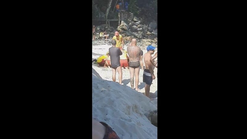Guarda-vidas tentando reanimar o homem Tragédia em Ubatuba: Homem despenca em rochedo, desmaia no mar e morre afogado Guarda-vidas em praia tentando reanimar homem afogado - Imagem: Reprodução