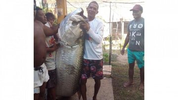Pescador afirma que peixe pesa quase o dobro que ele Pescador captura peixe de mais de 100 quilos no litoral do RN Homem com peixe gigante - Imagem: Reprodução