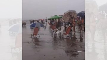 Flagrante aconteceu na tarde desta sexta-feira (31) no bairro Canto do Forte Turistas de Praia Grande permanecem na praia mesmo com forte chuva | VÍDEO Turistas na faixa de areia do bairro Canto do Forte, em Praia Grande, sob forte chuva - Reprodução/Instagram