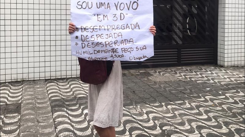 Situação da senhora fez com que internautas se mobilizassem para tentar localizá-la Mulher estava na esquina da rua Joaquim Távora com a avenida Ana Costa na tarde desta quarta-feira (2) Senhora segura placa pedindo ajuda em Santos - Raphaella Lancelloti/Grupo Facebook Viver em Santos e Região:Comunicados