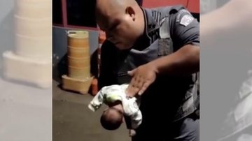 Policiais prestaram socorro imediatamente e conseguiram fazer a criança voltar a respirar, após realizar a manobra de Heimlich Policial militar salva recém-nascido que havia parado de respirar | VÍDEO Policial com o bebê no colo realizando a manobra de des - Reprodução Facebook