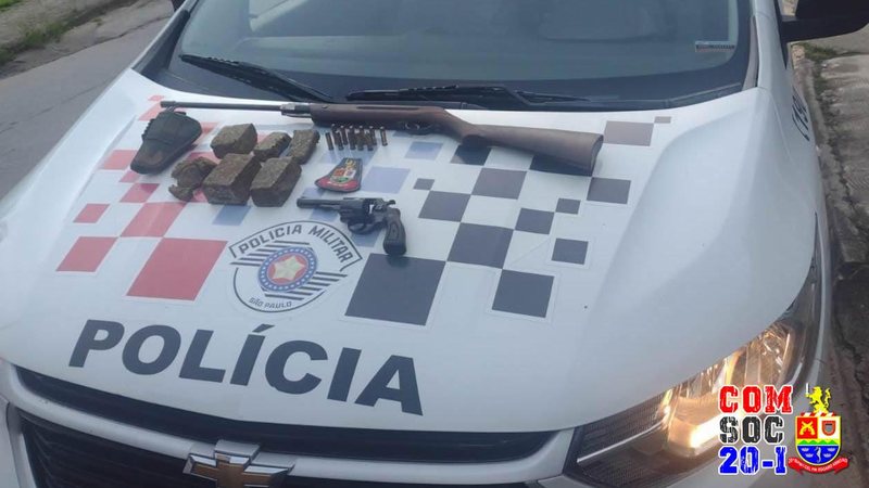 Arma, munições e drogas apreendidas pelos policiais Homem atira no vizinho e é preso por porte ilegal de arma e tráfico de drogas em Ilhabela (SP) Arma, munições e drogas sob capô de viatura - Foto: Polícia Militar