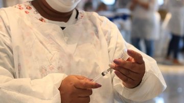 Durante os últimos 365 dias, o município já aplicou 895.226 doses, atingindo a marca de 83,25% da população com o ciclo vacinal completo Após um ano do início da vacinação em Santos, cidade comemora quase 900 mil doses aplicadas Enfermeira colocando o imun - Divulgação