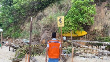 Local foi sinalizado e interditado pela Defesa Civil Parte de falésia desaba em praia da região norte do país Funcionário da Defesa Civil em frente ao local com sinalização de interdição - Divulgação