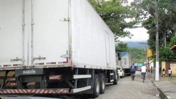 Proibição de entrada será entre 16 horas de sexta-feira até às 23h59 de domingo Entrada e circulação de caminhões em Ilhabela estão proibidos Caminhões parados em rua de Ilhabela - Divulgação