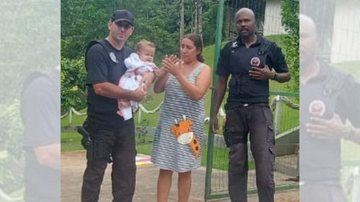 Criança foi reanimada e encaminhada à UPA (Unidade de Pronto Atendimento) Perequê-Mirim, para cuidados médicos Bebê de 11 meses que estava engasgado foi salvo por equipe de guarda parque em Caraguatatuba Guardas com o bebê no colo e a mãe ao lado - Reprodução