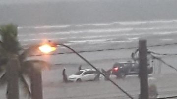 Automóvel pertence à um ambulante e de acordo com testemunhas, os GCMs não mediram esforços para ajudar o munícipe Carro fica atolado na praia após as fortes chuvas que caíram em Praia Grande Carro atolado send removido pela viatura da Romu - Reprodução