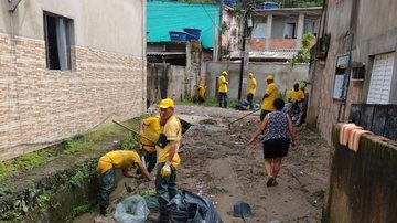 Trabalhadores da gestão municipal tentam reduzir estragos em bairros da cidade Guarujá tenta minimizar estragos das fortes chuvas Homens limpando lama - Imagem: Divulgação / Prefeitura de Guarujá