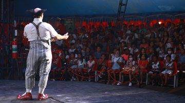 Espetáculo para crianças de entidades e abrigos é uma parceria entre a prefeitura da cidade com o Circo Stankowich Circo em Guarujá Palhaço de costas para a câmera e de frente para uma plateia com crianças - Divulgação