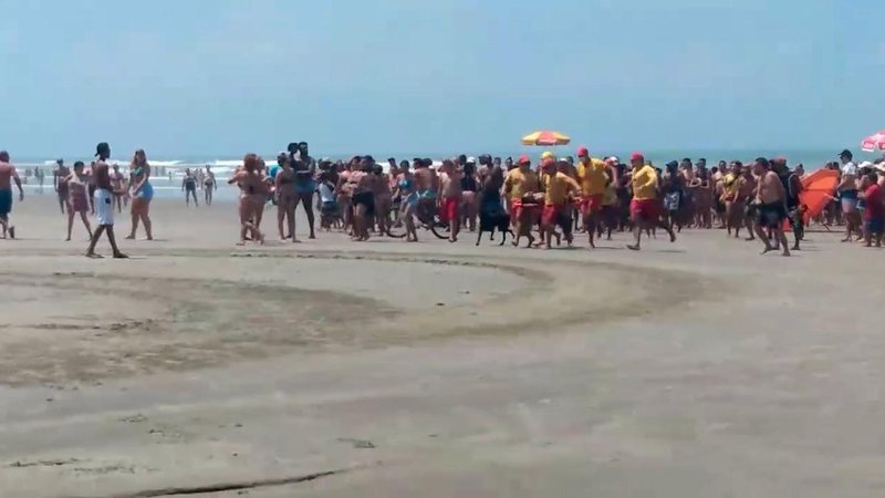Guarda-vidas durante resgate de um de três vítimas de afogamento, em praia do litoral de SP Afogamento - Vídeo mostra resgate dramático de turista afogado no litoral de SP Grupo de guarda-vidas correndo com homem afogado em praia - Imagem: Reprodução / Acervo Pessoal Célio Lopes