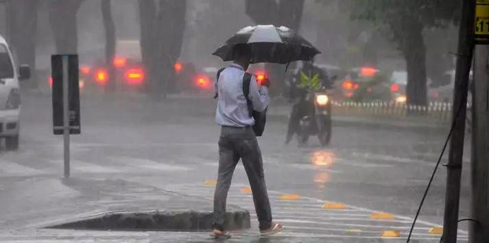 Previsão do tempo fevereiro TEMPO NO LITORAL Homem segurando guarda-chuva em meio a uma intensa chuva. Fim da descrição. - Juarez Rodriguesm/D.A Press
