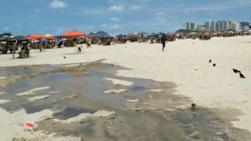 Agentes da prefeitura foram até o local e identificaram um forte odor Vazamento de esgoto na praia de pitangueiras, Guarujá Esgoto escorrendo na areia da Praia de Pitangueiras, ao lado de pessoas que estavam embaixo do guarda sol - Divulgação/Prefeitura de Guarujá