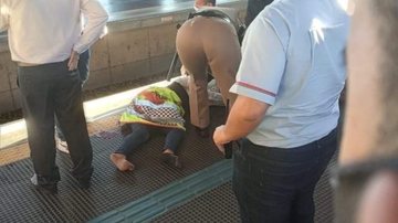 Quando o trem parou a passageira foi empurrada contra as portas, que estavam fechadas Mulher cai no vão de trem em São Paulo Mulher caída no chão da plataforma sendo atendida - Reprodução