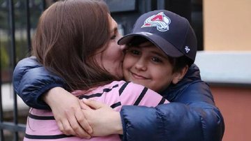 Jovem reencontrou a mãe na Eslováquia após ambos fugirem da guerra Fugitivo da Ucrânia Menino de boné abraçando a mãe - Divulgação