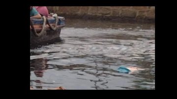 Passageiros de pequena embarcação avistaram o corpo no início da manhã Cadáver aparece boiando em águas de Santos (SP) Barco em águas e corpo boiando ao lado - Imagem: Rebeca Ribeiro