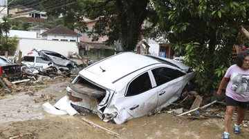 Imagem ilustrativa para mostrar um dos resultados de temporal em uma região Temporal Imagem de uma mulher devastada ao lado direito e um carro ao centro inundado - © Tânia Rêgo/Agência Brasil