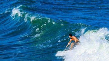 Campeonato será em frente ao quiosque ‘Marllon Lanches’ na Avenida Ayrton Senna, das 8h às 16h Surf Pessoa surfando em mar azul - Imagem ilustrativa