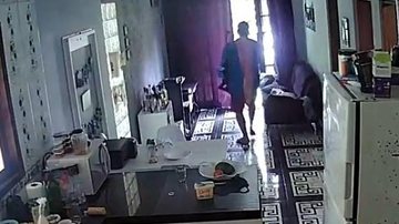 A câmera de segurança da residência capturou o exato momento em que o infrator leva os pertences das vítimas para fora da casa. - Câmeras de Segurança
