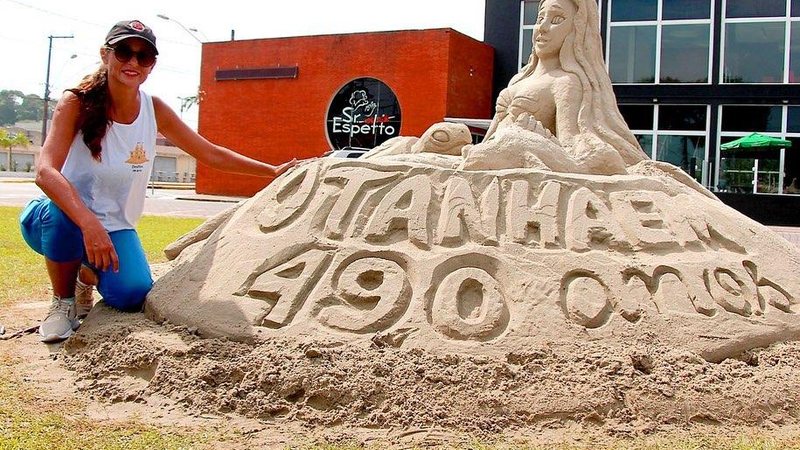 Itanhaém completou 490 anos na última semana Itanhaém ganha escultura de areia de presente de aniversário Artista ao lado da escultura de areia em comemoração aos 490 anos de Itanhaém - Prefeitura de Itanhaém