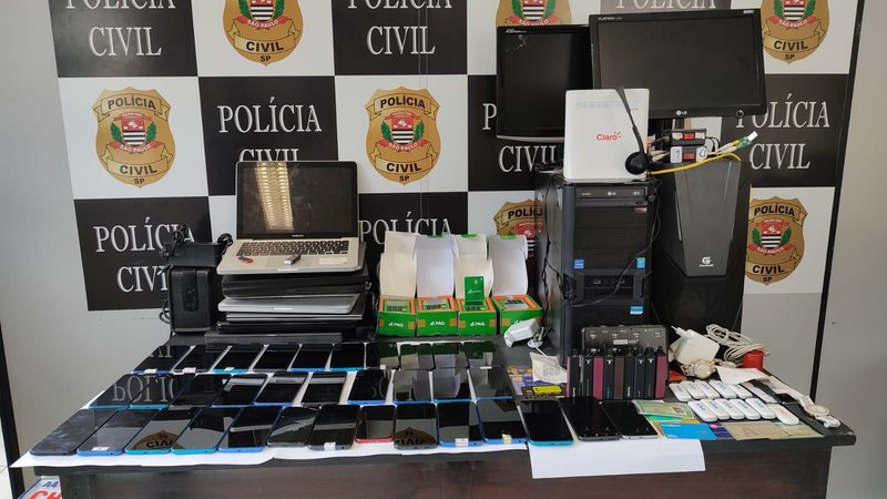 Entre os objetos apreendidos estão 37 celulares, nove notebooks, quatro máquinas de cartão de crédito, chips de celulares e 14 modems Polícia descobre central clandestina de golpes eletrônicos no litoral de SP Objetos eletrônicos apreendidos pela polícia - Assessoria de Imprensa Polícia Civil - Deinter-6