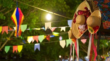 Evento será marcado por danças juninas tradicionais e venda de comidas típicas Festa Junina Bandeiras coloridas de festa junina e ao lado chapéus caipiras - Reprodução/Solutudo