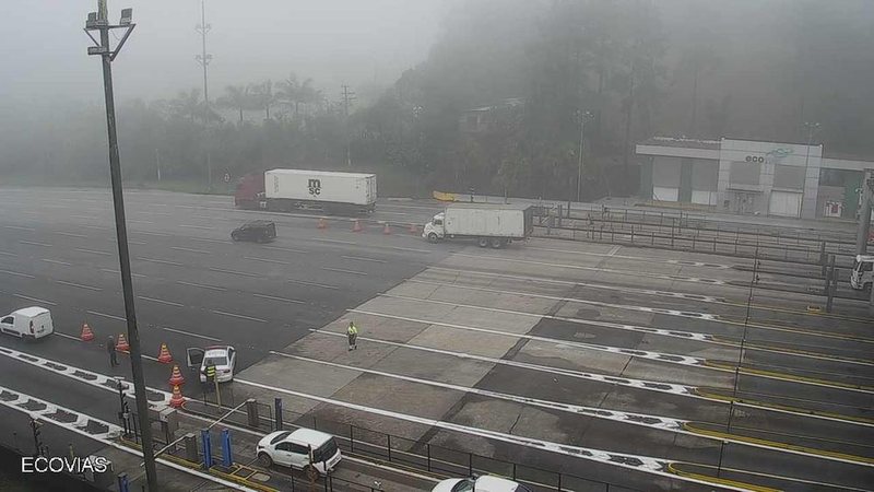 O tempo está encoberto e com chuva em pontos isolados e neblina no topo da serra Via Anchieta segue com Operação Comboio nesta quinta (2) Pedágio da via Anchieta com neblina - Ecovias