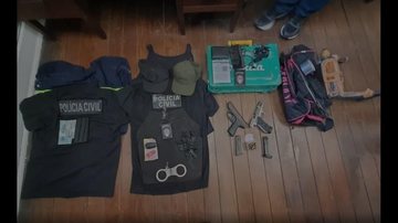 Objetos apreendidos com policiais de mentira Policiais de mentira são presos de verdade durante roubo em Santos Itens policiais em chão de madeira - Imagem: Divulgação / Polícia Militar
